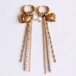 Oorbellen met glanzende strengen, strassstenen, hart en parel